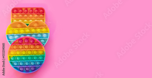 colorful antistress sensory toy fidget push pop it on pink background