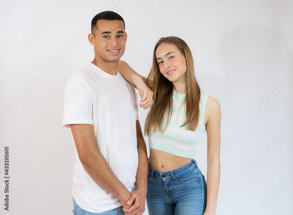 Cute young couple embracing and looking the camera on white background Cute young couple embracing and looking the camera on white background