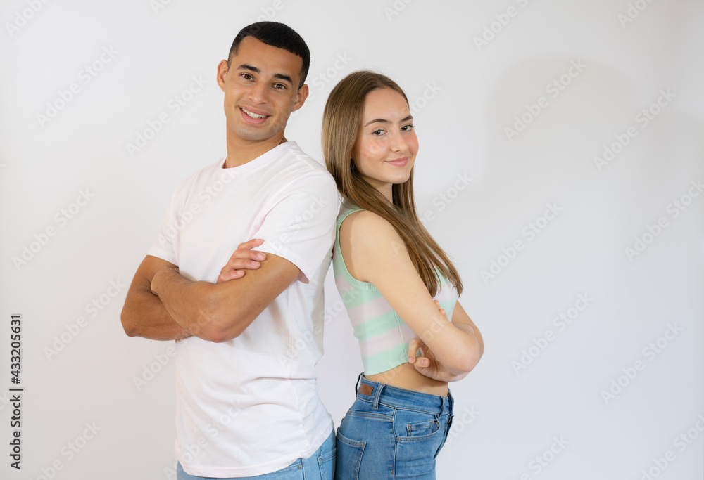 Happy loving couple. Studio shot of beautiful young couple in casual clothes standing back to back and smiling Happy loving couple. Studio shot of beautiful young couple in casual clothes standing back to back and smiling