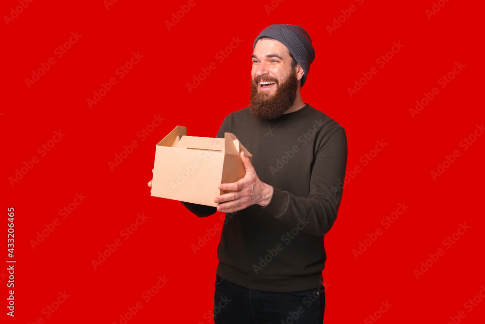 Photo of smiling young man with beard holding lunch box Photo of smiling young man with beard holding lunch box