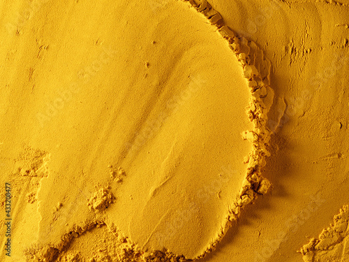 Yellow powder of grated turmeric. View from above.