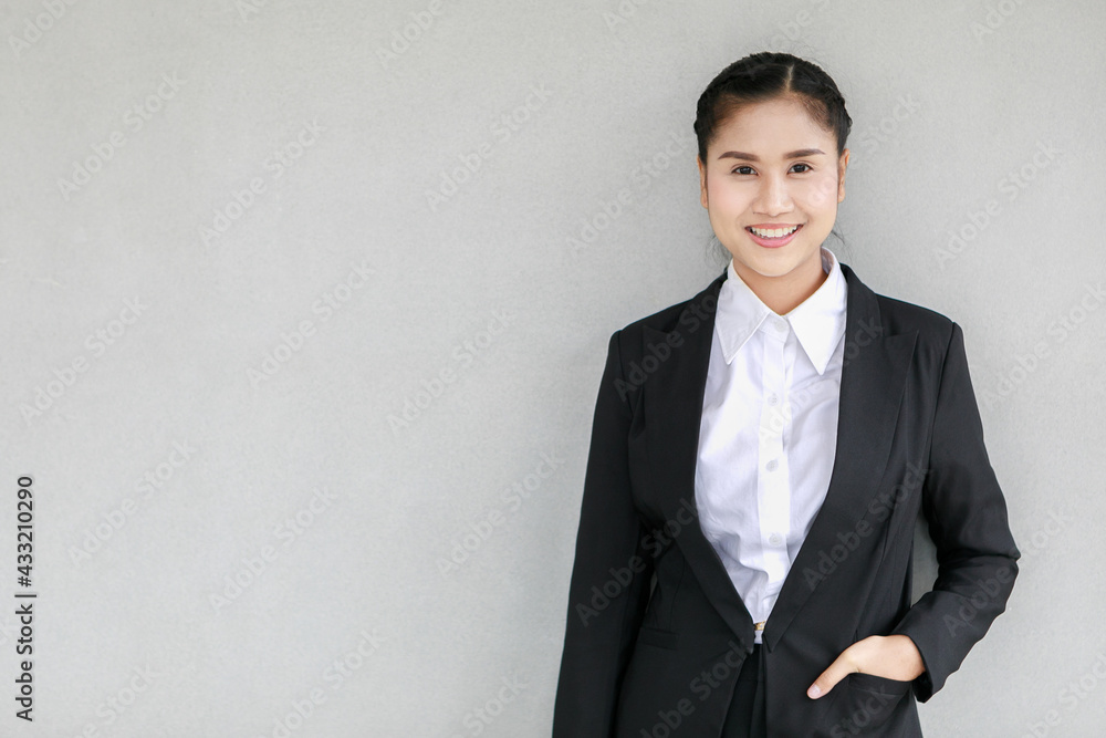 Portrait closeup shot of Asian female smart successful female businesswoman with braid hairstyle wears formal black suit with white shirt stand smiling look at camera put hand in jacket pocket Portrait closeup shot of Asian female smart successful female businesswoman with braid hairstyle wears formal black suit with white shirt stand smiling look at camera put hand in jacket pocket