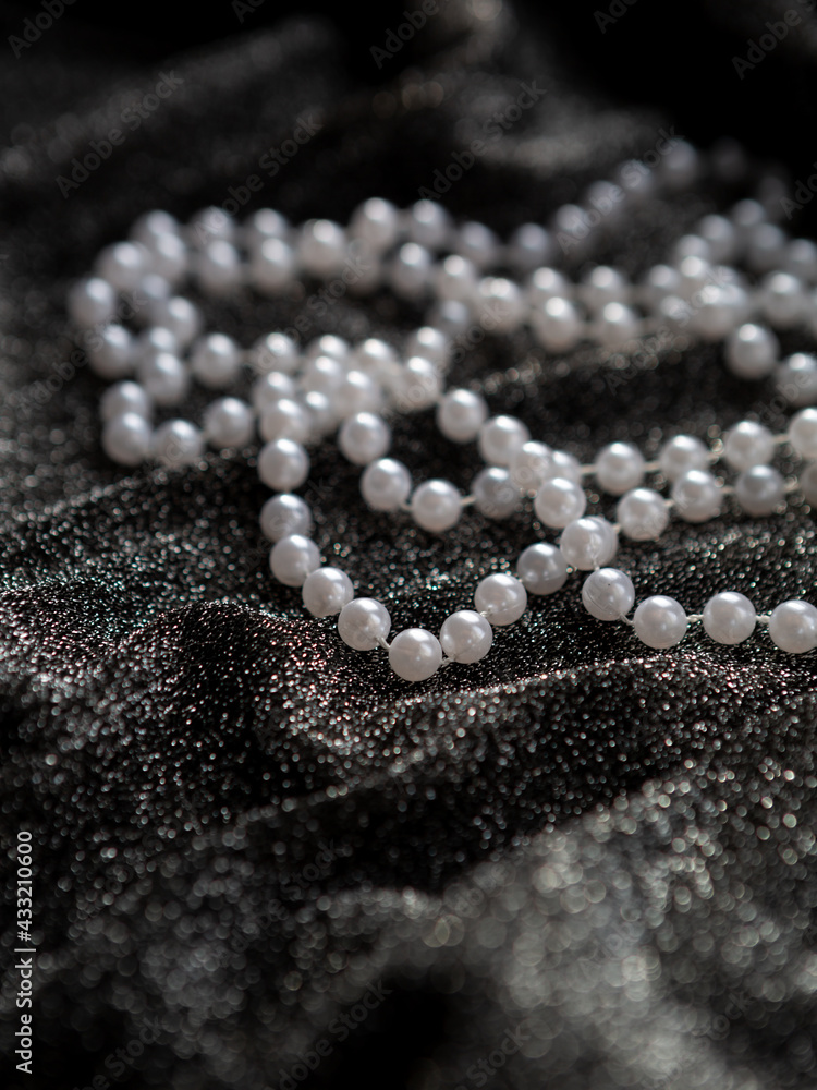 A string of white pearls on a black background A string of white pearls on a black background