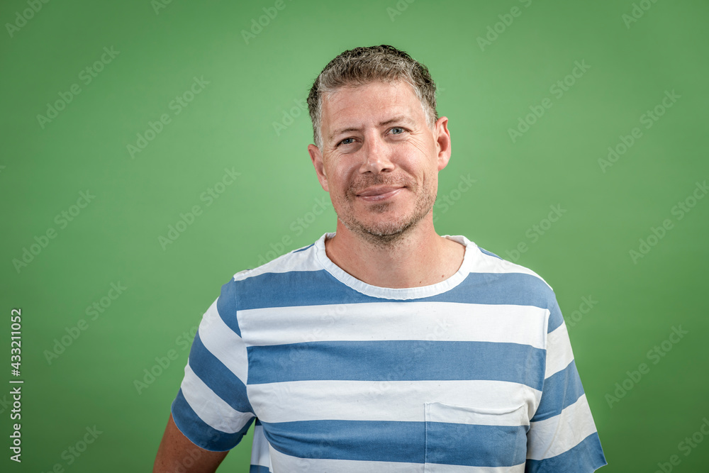 good looking Man in early 40s with gray hair and three day beard with white  blue striped t-shirt posing in front of green background Stock Photo |  Adobe Stock