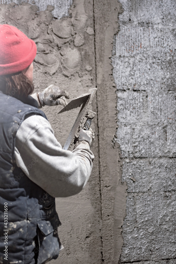 Real construction worker working on a wall inside the new house. Real construction worker working on a wall inside the new house.