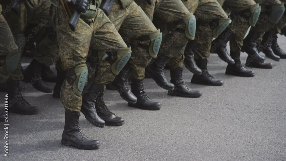 Military men in camouflage march on the spot in the city square during a military parade. Military men in camouflage march on the spot in the city square during a military parade.