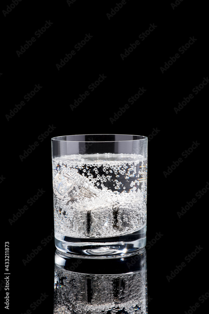 Glass of Soda or Coctail with steel cooling cubes on dark glass background Glass of Soda or Coctail with steel cooling cubes on dark glass background