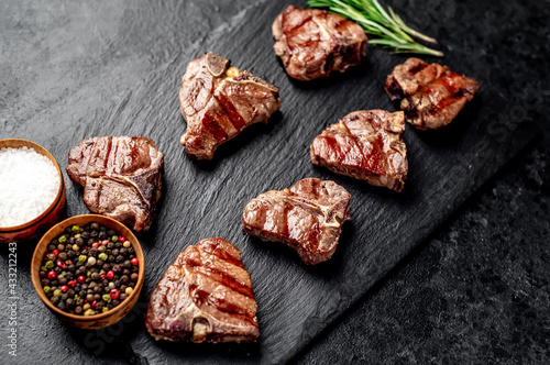 several mini Grilled beef T-bone steaks on stone background