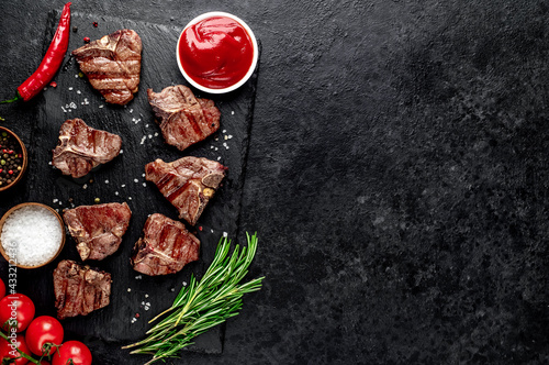 several mini Grilled beef T-bone steaks on stone background with copy space for your text