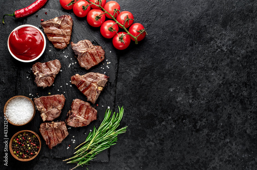 several mini Grilled beef T-bone steaks on stone background with copy space for your text