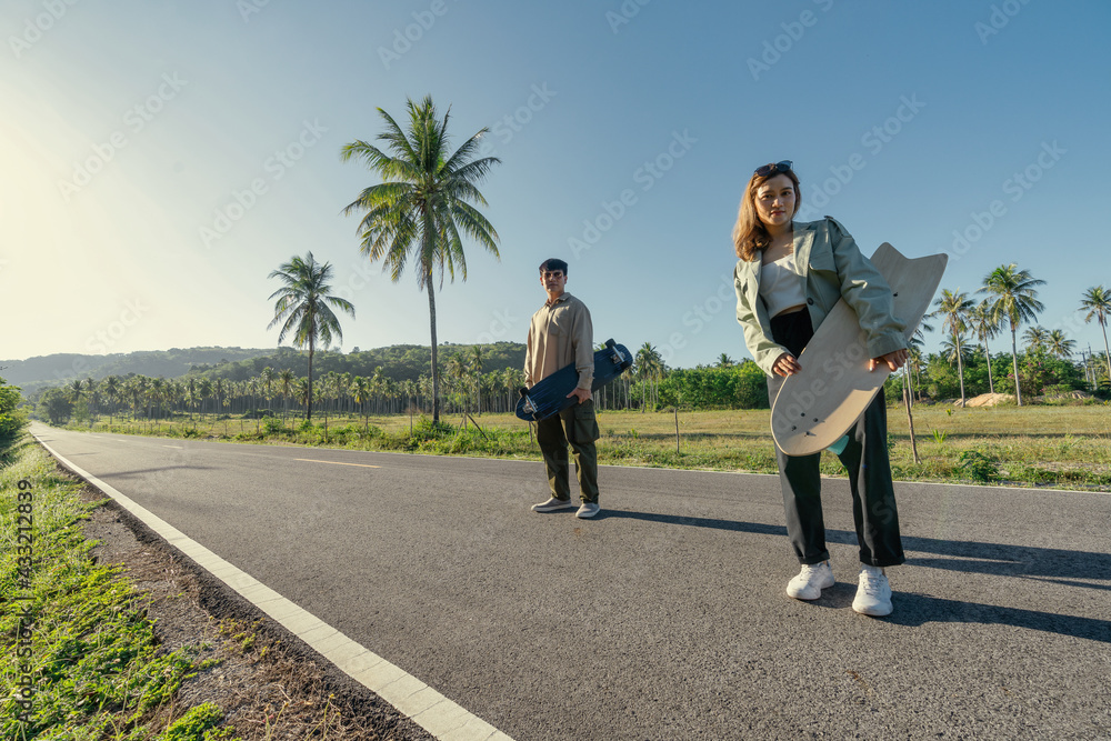 Portrait of Asian Lover Couple with Trendy Sport Equipment SurfSkate Portrait of Asian Lover Couple with Trendy Sport Equipment SurfSkate