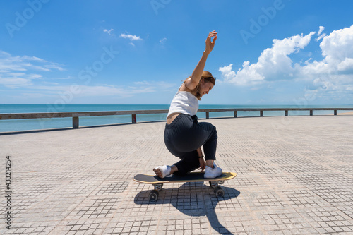 Young asian women riding surfskate board. Trendy outdoor sport in Thailand, Asia. photo