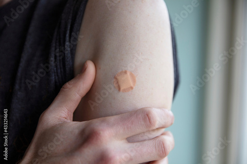 Caucasian man with a plaster on their arm after a vaccination injection