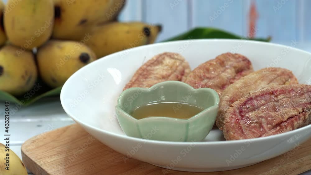 Thai grilled bananas serve with honey or coconut caramel syrub. Selective focus and free space for text. Clean vegetarian food for good health. Shooting in studio for advertisement. Thai grilled bananas serve with honey or coconut caramel syrub. Selective focus and free space for text. Clean vegetarian food for good health. Shooting in studio for advertisement.