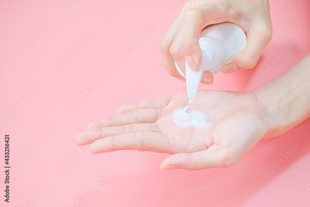 Woman applying moisturizing hand cream on hand with pink background, Health care concept. Woman applying moisturizing hand cream on hand with pink background, Health care concept.