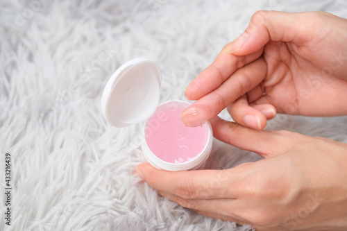 Woman applying dry skin gel on foot with carpet background  Health care concept.