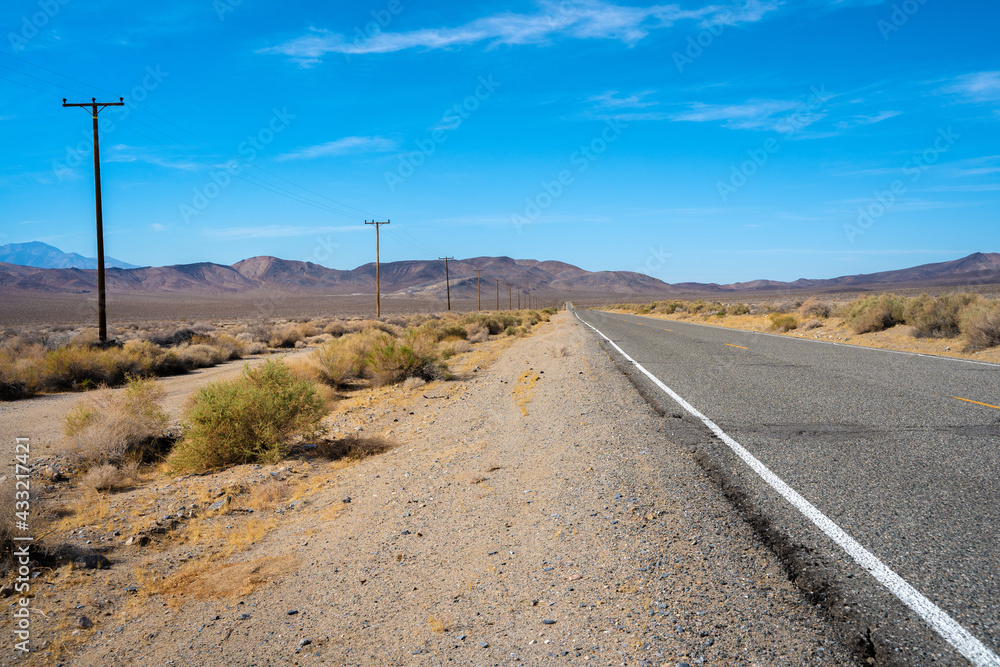 Desert scenic road in Death Valley with mountain backdrop, California, USA. Amazing panorama of desert Desert scenic road in Death Valley with mountain backdrop, California, USA. Amazing panorama of desert