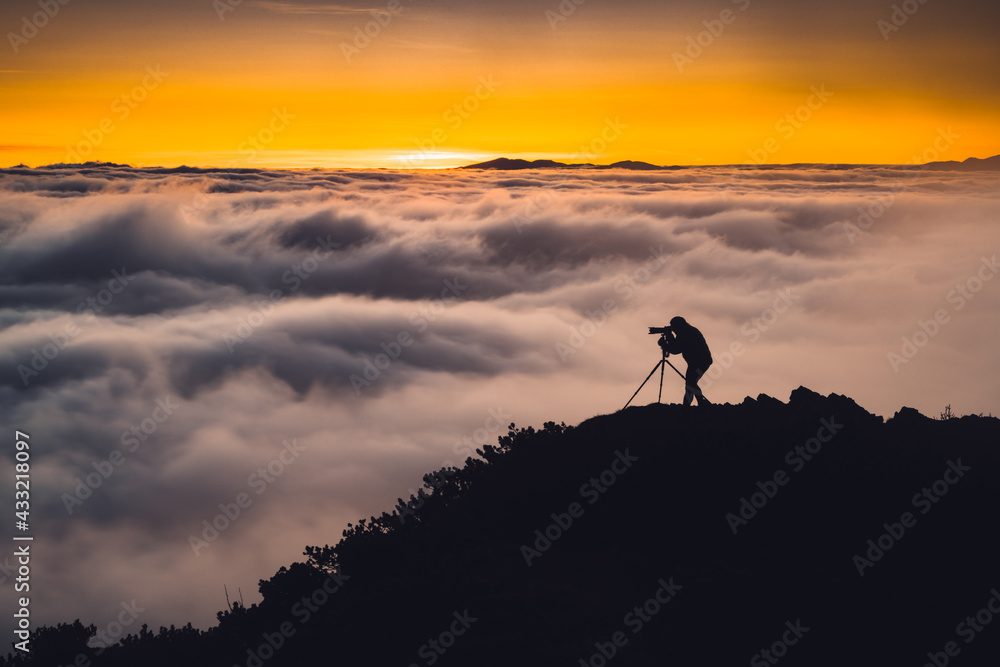 silhouette of a photographer on the top of a mountain