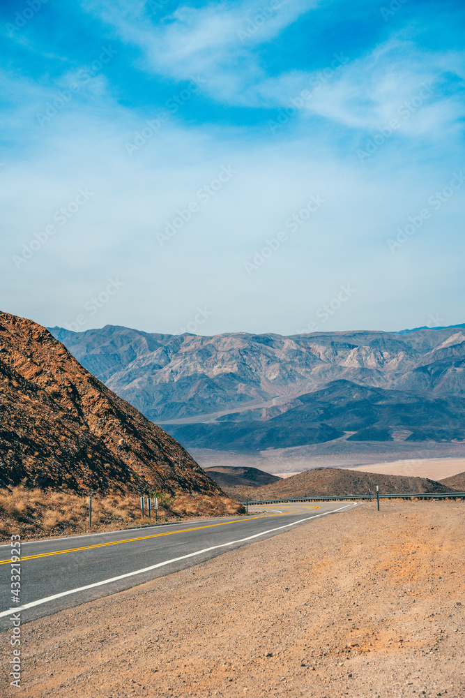 Desert scenic road in Death Valley with mountain backdrop, California, USA. Amazing panorama of desert