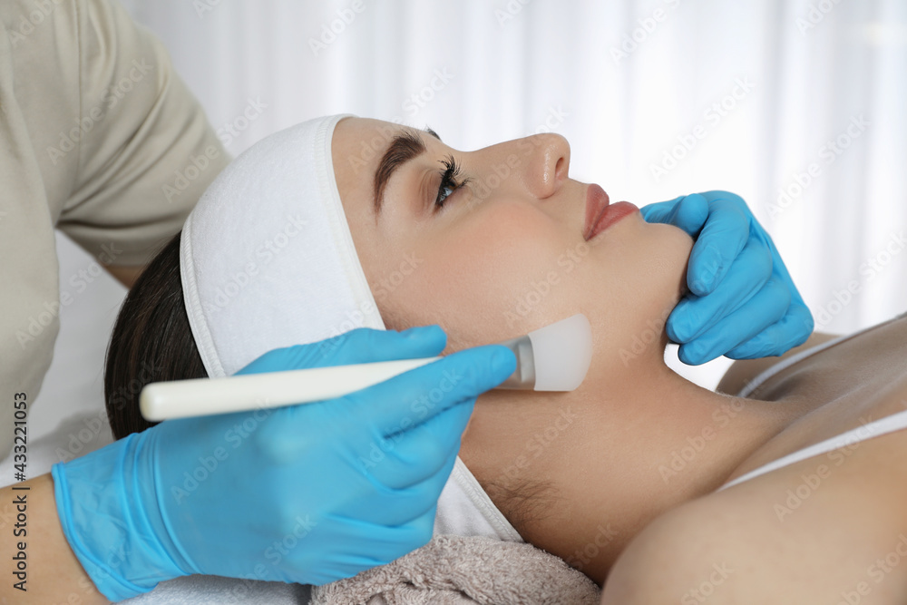 Young woman during face peeling procedure in salon Young woman during face peeling procedure in salon