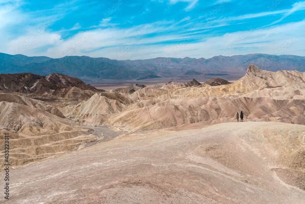 Fototapeta premium Amazing view of the hills in Zabriskie Point Death Valley National Park, USA. In the distance, small silhouettes of people