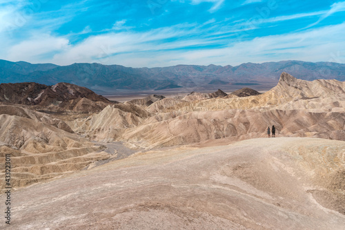 Amazing view of the hills in Zabriskie Point Death Valley National Park, USA. In the distance, small silhouettes of people