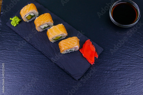 Sushi rolls Philadelphia on a black slate. Top view