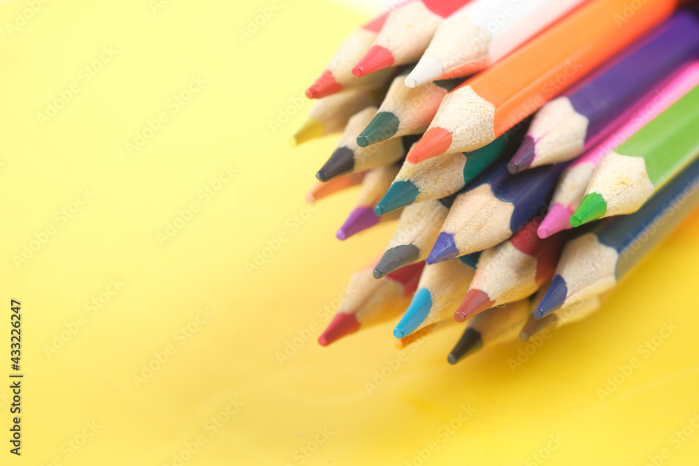 Close up of colorful drawing pencils on yellow Close up of colorful drawing pencils on yellow