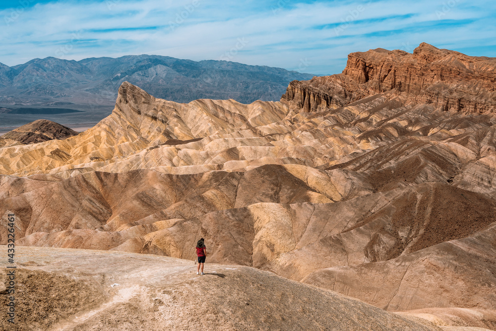 Fototapeta premium Amazing view of the hills in Zabriskie Point Death Valley National Park, USA. In the distance, small silhouettes of people