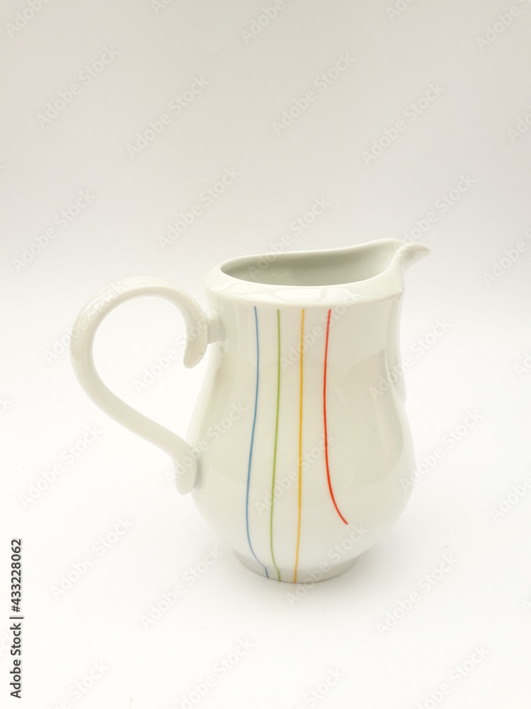 Mid-century modern porcelain saucer, cream jug with lines pattern isolated Mid-century modern porcelain saucer, cream jug with lines pattern isolated