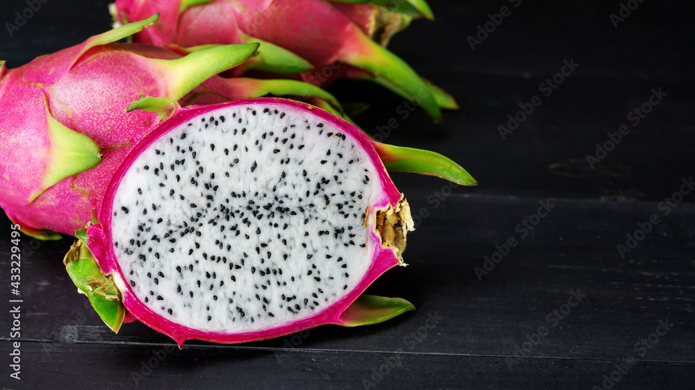 Fresh dragon fruit on a black wooden table. Fresh dragon fruit on a black wooden table.