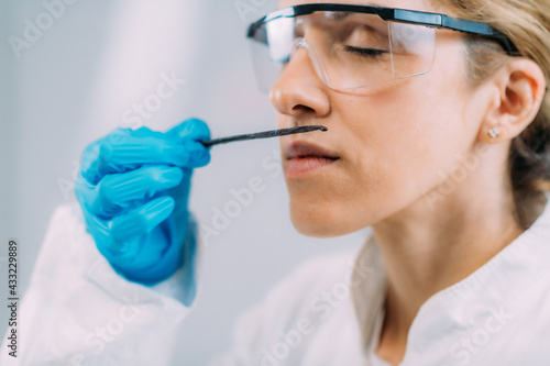 Fototapeta Naklejka Na Ścianę i Meble -  Olfaction Test. Female Scientist Examining Vanilla Smell.