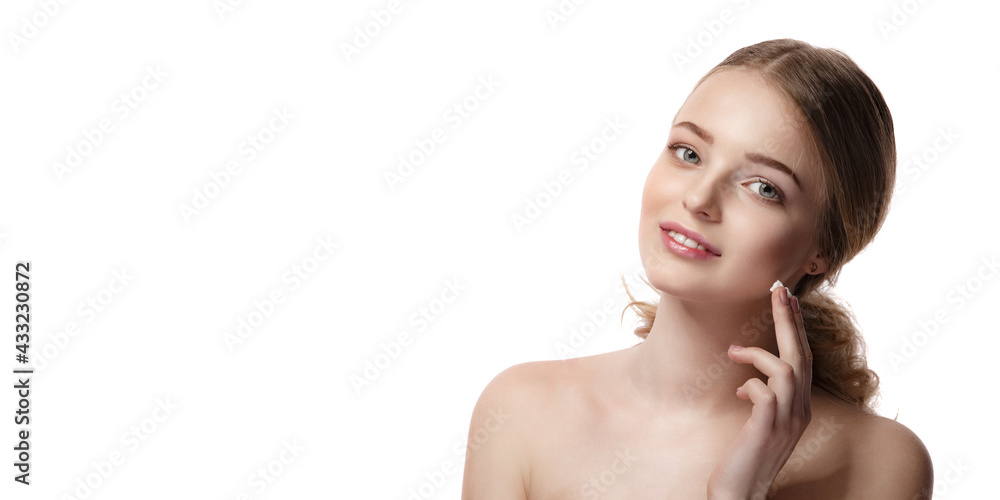 Portrait of young beautiful woman smiling while taking some facial cream isolated on white background with copy space Portrait of young beautiful woman smiling while taking some facial cream isolated on white background with copy space
