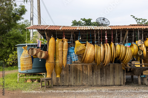 Fotografi Lots of wickerwork hanging up for retail sale in the countryside.