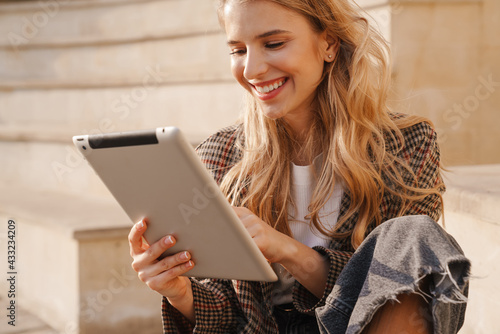 Smiling young blonde woman holding tablet photo