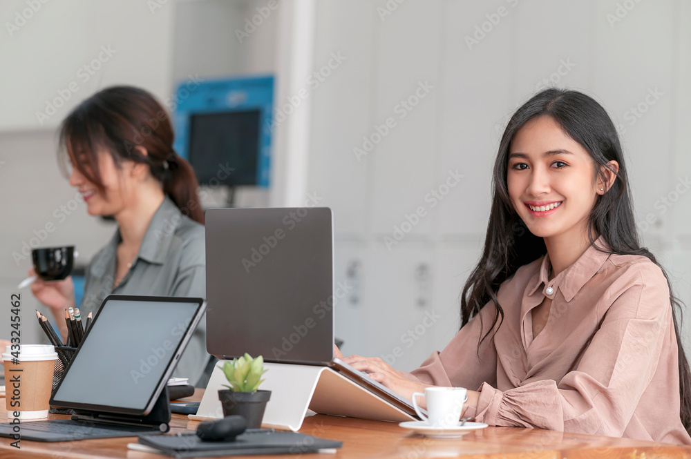 Young successful businesswoman working at office with her friend. Young successful businesswoman working at office with her friend.