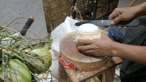 Peeling Thai coconut skin in the traditional way. Which keeping coconut skin and water fresh inside. Young coconut peeled by hand. Thailand Local style of peeling coconut. Asian famous food and drink