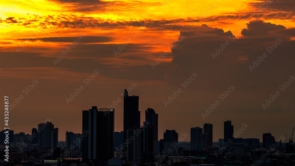 Fototapeta premium The blurred abstract background of the morning sun exposure to the tiny dust particles that surround the tall buildings in the capital, the long-term health issue of pollution.
