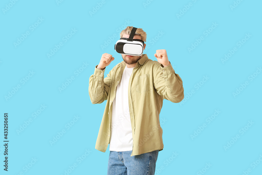 Young man with VR glasses on color background Young man with VR glasses on color background