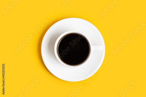 Foto Top view of the white cup of coffee on the yellow background with a free space for text