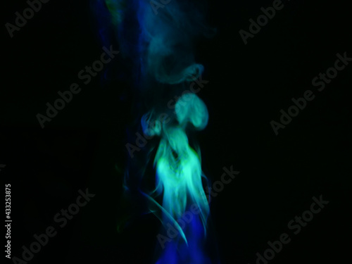 Abstract color series. Composition of colorful smoke in motion. Fusion of blue and green mist isolated on a dark background to inspire creativity.