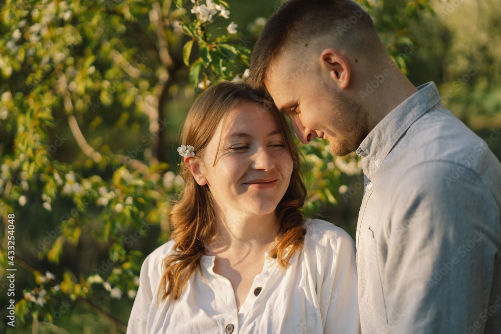 Young beautiful couple hugging in the spring garden. Young beautiful couple hugging in the spring garden.