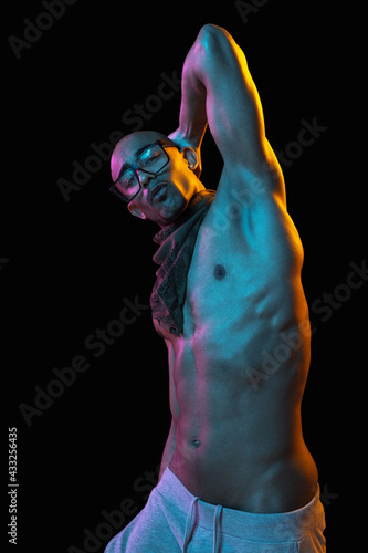 African-american young man's portrait on black studio background in neon. Concept of fashion, man's beauty, youth culture, performance.