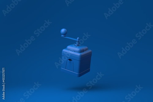 Blue Manual coffee grinder floating in blue background. minimal concept idea creative. monochrome. 3D render.