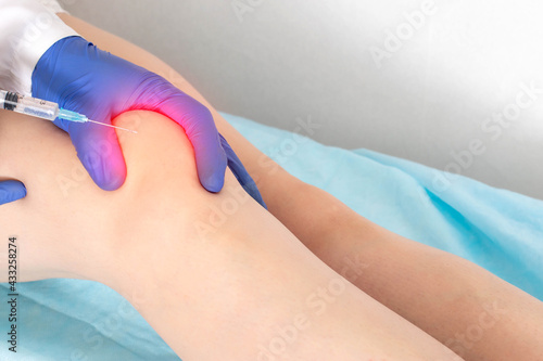 Bild auf Leinwand The doctor makes a puncture with intra-articular injection of drugs into the patient's knee joint