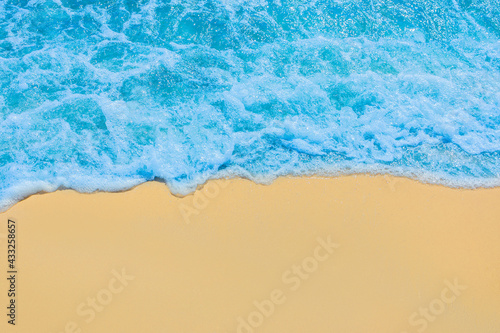 Blue seaside water on light yellow beach sand coastline seashore background