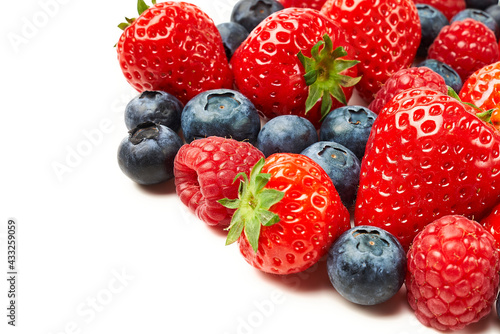Strawberries, raspberries and blueberries on a white background.