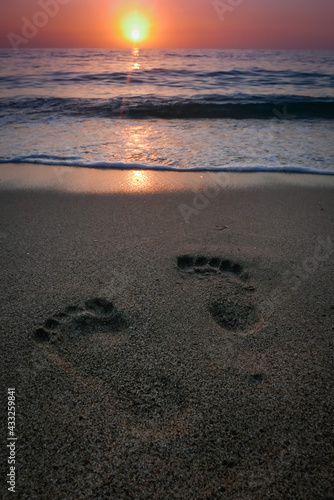 orme di piedi in spiaggia al tramonto