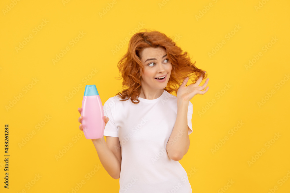 Beautiful woman with organic shampoo over light yellow background. curly hair Beautiful woman with organic shampoo over light yellow background. curly hair