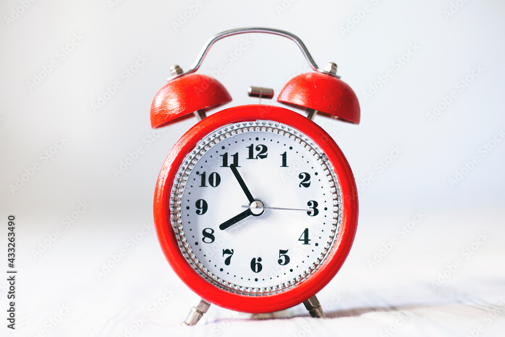 Time optimization concept. Alarm clock on bed background, close up view Time optimization concept. Alarm clock on bed background, close up view